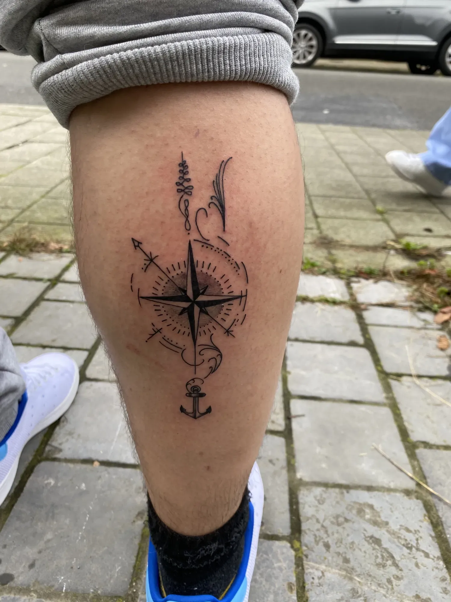 Black & grey kompas met pijl op de kuit, tattoo Gent