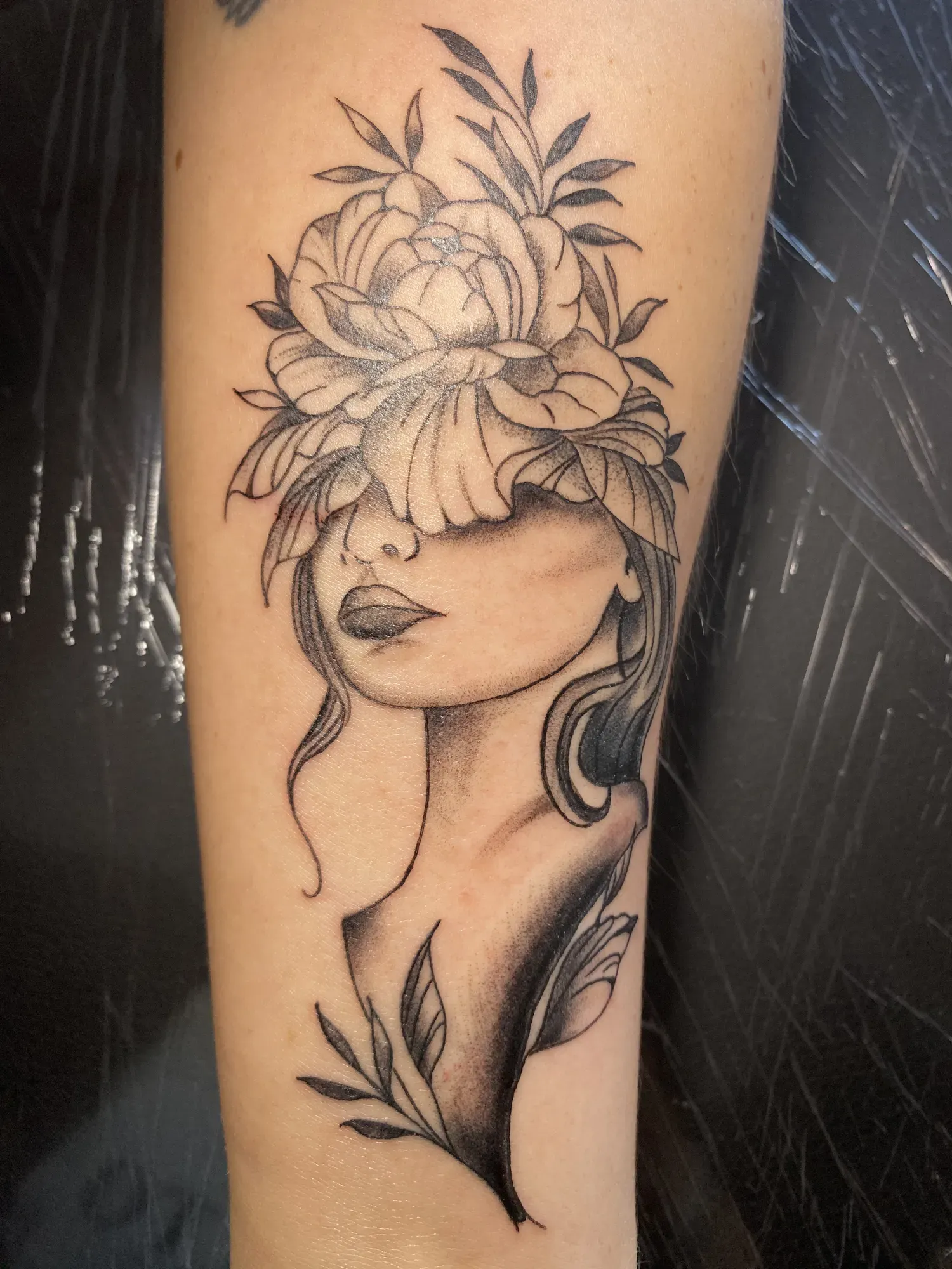 Black & grey vrouwenportret met bloemen in het haar, tattoo Gent