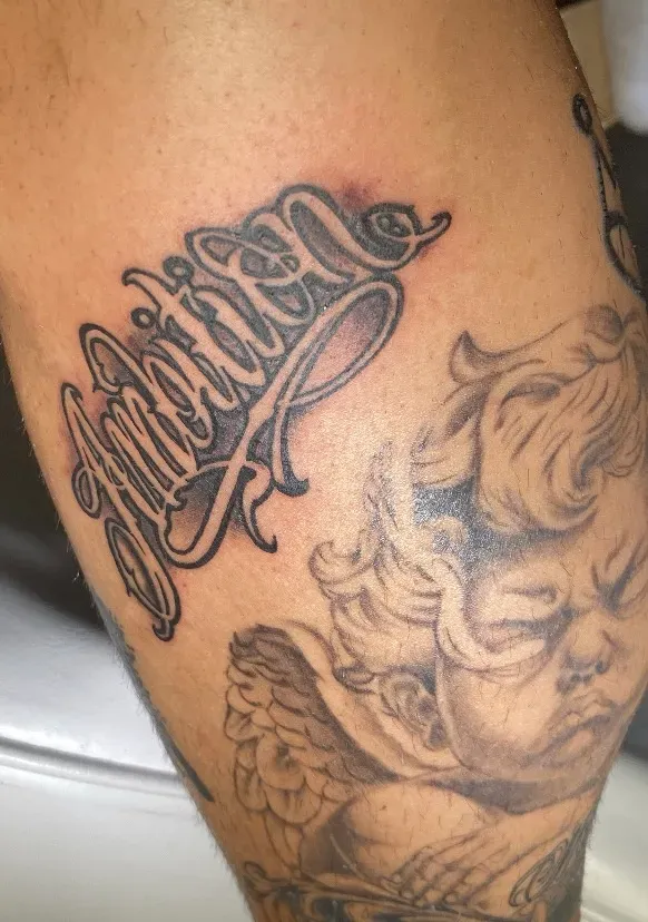 Black & grey sierschrift met cherubijn op de arm, tattoo Gent